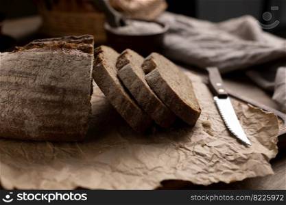 Homemade bread with parchment paper on wood table. Bread at wooden tabletop as baking concept