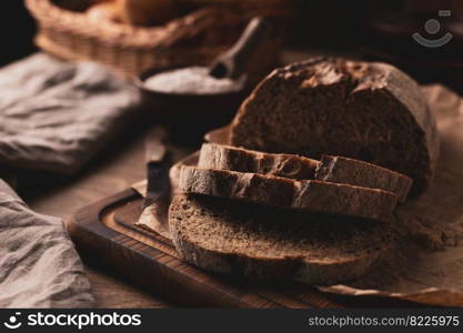 Homemade bread with parchment paper on wood table. Bread at wooden tabletop as baking concept