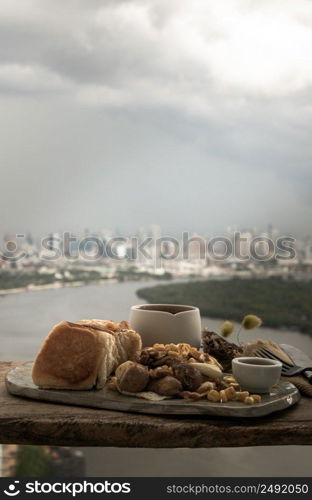 Homemade breakfast with Breads and Stuffed omelette with chicken, garlic and cheese sprinkled with sweet corn and honey served with cup of coffee on rustic old wooden table with beautiful scenery in the morning. Selective Focus.