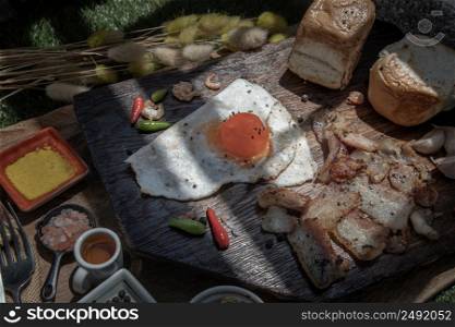 Homemade breakfast with Fried egg, Fried bacon and Toasts served with Honey on Wooden cutting board. Healthy food concept, Selective Focus.