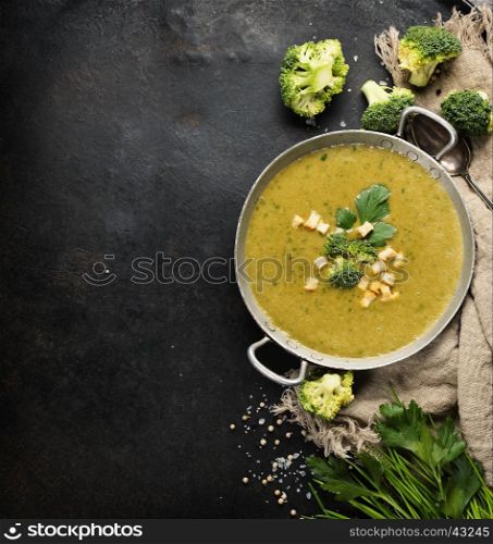 Homemade broccoli soup puree on a dark rustic background