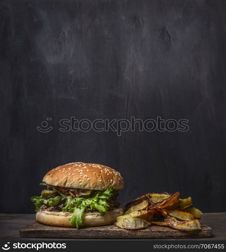 homemade burger with tuna and fried potatoes with dill and garlic on a cutting board on wooden rustic background border, place for text