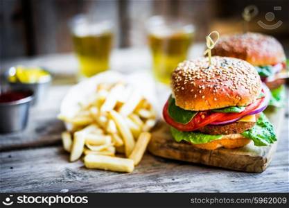 Homemade burgers on rustic wooden background