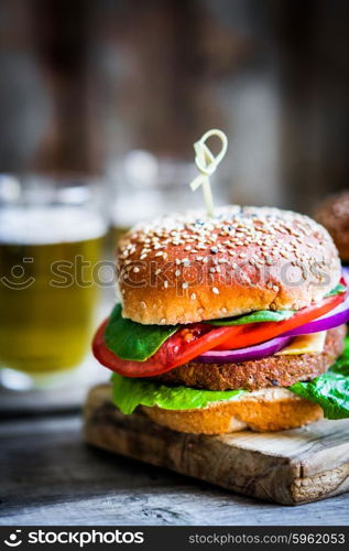 Homemade burgers on rustic wooden background