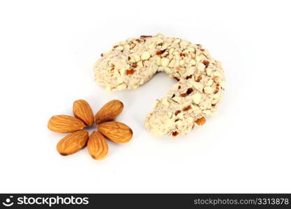 Homemade cake in shape of crescent with some almonds, isolated on white