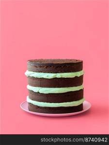 Homemade cake with peppermint cheese cream and chocolate base. Layered cake with mint flavor cream minimalist on a pink table
