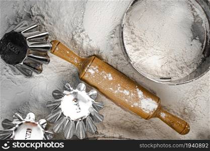 Homemade cakes. Rolling pin and sieve in flour on the table. Top view. On a white background.. Homemade cakes. Rolling pin and sieve in flour on the table. Top view.