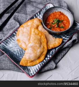 Homemade chebureks with filling and salsa sauce