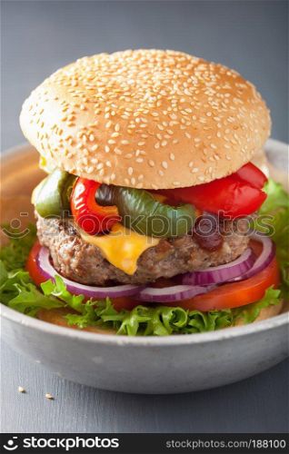 homemade cheese burger with peppers tomato onion