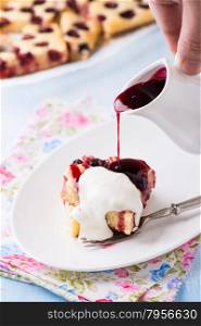 Homemade cherry cake with cream and pouring sauce on plate, selective focus