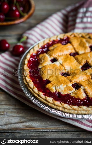 Homemade cherry pie on rustic background