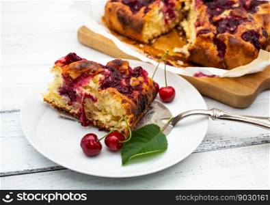 Homemade cherry pie on white rustic wood background.