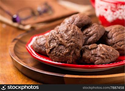 Homemade chocolate cookies on red plate, selective focus