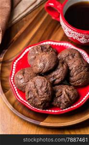 Homemade chocolate cookies on red plate, selective focus