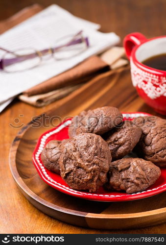 Homemade chocolate cookies on red plate, selective focus