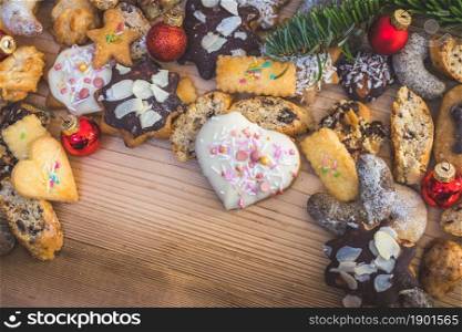 Homemade Christmas cookies, powdered sugar and Christmas bauble on a rustic wooden table. Copy Space.
