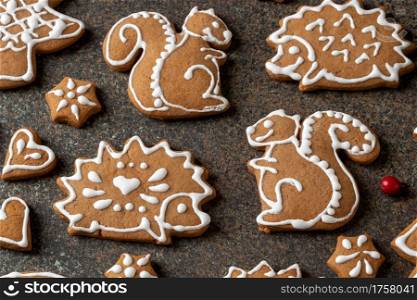 Homemade Christmas gingerbread cookies in the form of squirrels and hedgehogs on a dark background