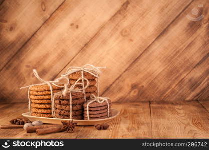 Homemade corded wholegrain cookies with oatmeal, linen and sesame seeds and traditional cookies with chocolate chips on dark rustic wooden table and spice.. Various shortbread, oat cookies, chocolate chip biscuit and spice on dark rustic wooden table.