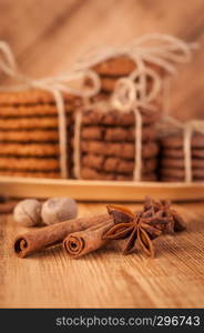 Homemade corded wholegrain cookies with oatmeal, linen and sesame seeds and traditional cookies with chocolate chips on dark rustic wooden table and spice.. Various shortbread, oat cookies, chocolate chip biscuit and spice on dark rustic wooden table.