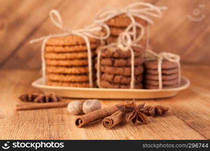 Homemade corded wholegrain cookies with oatmeal, linen and sesame seeds and traditional cookies with chocolate chips on dark rustic wooden table and spice.. Various shortbread, oat cookies, chocolate chip biscuit and spice on dark rustic wooden table.