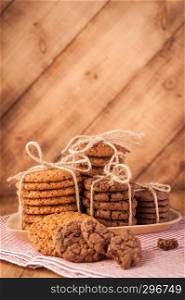 Homemade corded wholegrain cookies with oatmeal, linen and sesame seeds and traditional cookies with chocolate chips on dark rustic wooden table.. Various shortbread, oat cookies, chocolate chip biscuit on dark rustic wooden table.