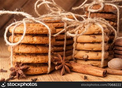 Homemade corded wholegrain cookies with oatmeal, linen and sesame seeds and traditional cookies with chocolate chips on dark rustic wooden table and spice.. Various shortbread, oat cookies, chocolate chip biscuit and spice on dark rustic wooden table.