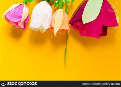 homemade corrugated paper flowers on yellow background