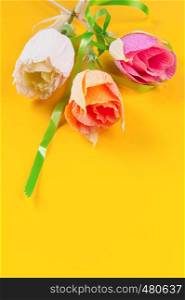 homemade corrugated paper flowers on yellow background