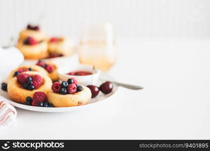 Homemade cottage cheese pancakes with fresh berries on white table