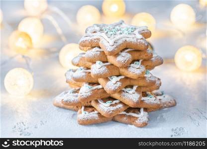 Homemade decorated gingerbread Christmas tree on the white wooden background