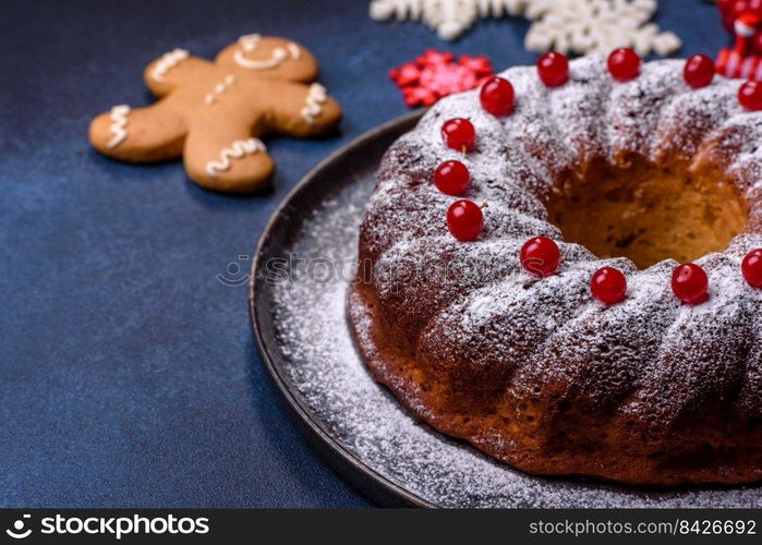 Homemade delicious round Christmas pie with red berries on a ceramic plate against a dark concrete background. Homemade delicious round Christmas pie with red berries on a ceramic plate