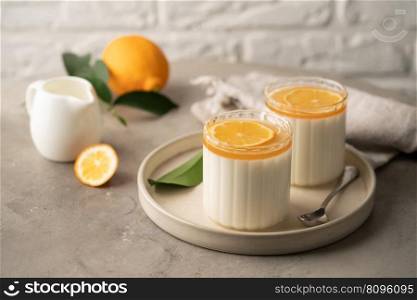 Homemade dessert panna cotta, mousse or pudding in a portion glass with lemon curd and fresh lemon.. Dessert panna cotta with lemon