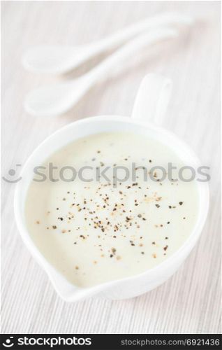 Homemade French Bechamel or White Sauce served in sauce boat, photographed with natural light (Selective Focus, Focus one third into the image). Bechamel or White Sauce