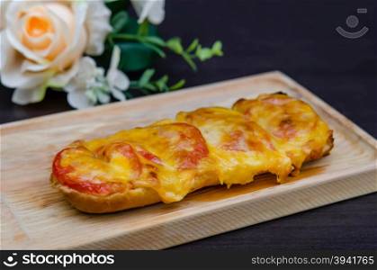 homemade French bread roll, topped with fresh tomatoes, melted cheddar, Mozzarella and Parmesan .