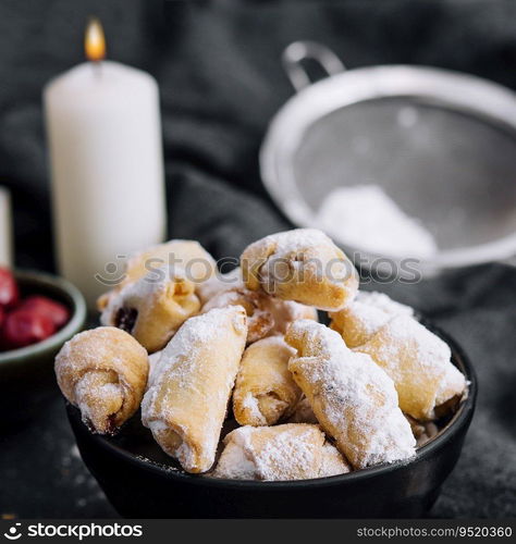 Homemade fresh cookies dusted powdered sugar in black bowl