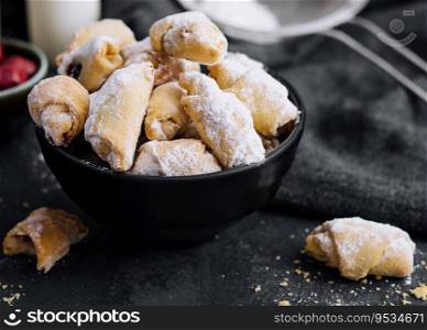 Homemade fresh cookies dusted powdered sugar in black plate