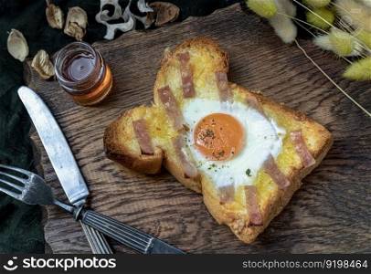 Homemade fried egg in a hole Bacon and Cheese toast serve with Honey on wooden cutting board. Sandwiches for breakfast, The concept of delicious food, Selective Focus.