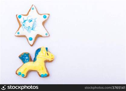 Homemade gingerbread cake pony and star with icing and colorful decoration on white as background. Holiday handmade decoration concept.