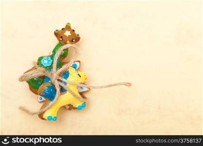 Homemade gingerbread cake pony christmas tree and star with icing and colorful decoration and string on brown paper background. Holiday handmade decoration concept.