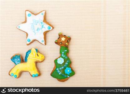 Homemade gingerbread cake pony christmas tree and star with icing and colorful decoration on brown as background. Holiday handmade decoration concept.