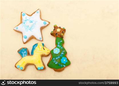 Homemade gingerbread cake pony christmas tree and star with icing and colorful decoration on brown paper background. Holiday handmade decoration concept.