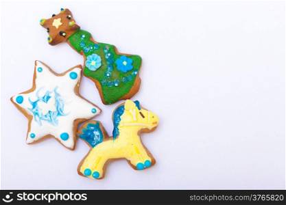 Homemade gingerbread cake pony christmas tree and star with icing and colorful decoration on white as background. Holiday handmade decoration concept.