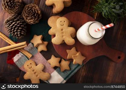 Homemade gingerbread man cookies and milk, traditionally made at Christmas and the holidays. Table top view.