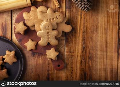 Homemade gingerbread man cookies, traditionally made at Christmas and the holidays. Top view image on rustic wooden background with copy space.