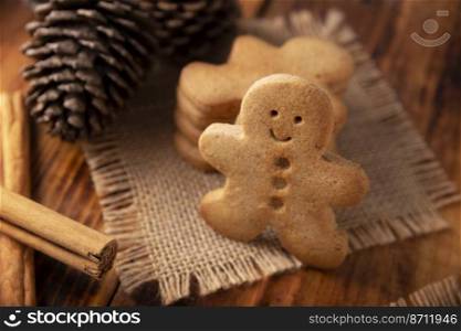 Homemade gingerbread men cookies and star shaped cookies on rostic wooden table, traditionally made at Christmas and the holidays.