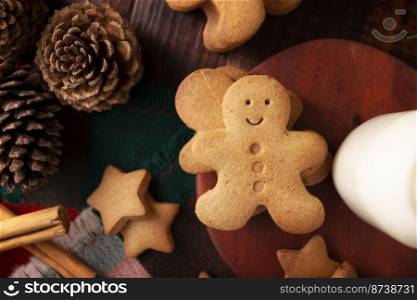 Homemade gingerbread men cookies on rustic wooden table, traditionally made at Christmas and the holidays.