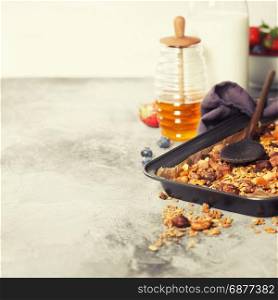 Homemade granola breakfast on rustic table. Healthy breakfast of almond milk, honey, berries, oatmeal, muesli, nuts, seeds and dried fruit.