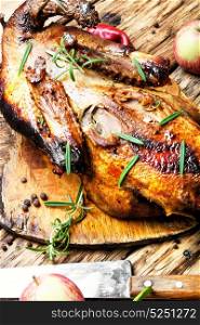 Homemade grilled duck. roast duck and apples on a wooden cutting board