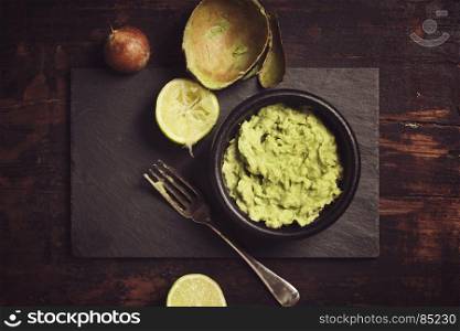 Homemade guacamole sauce on rustic background