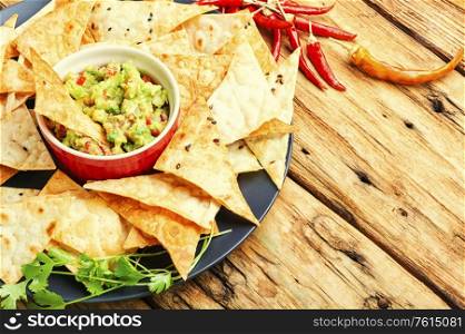 Homemade guacamole with corn chips on a old wooden table. Guacamole with chips